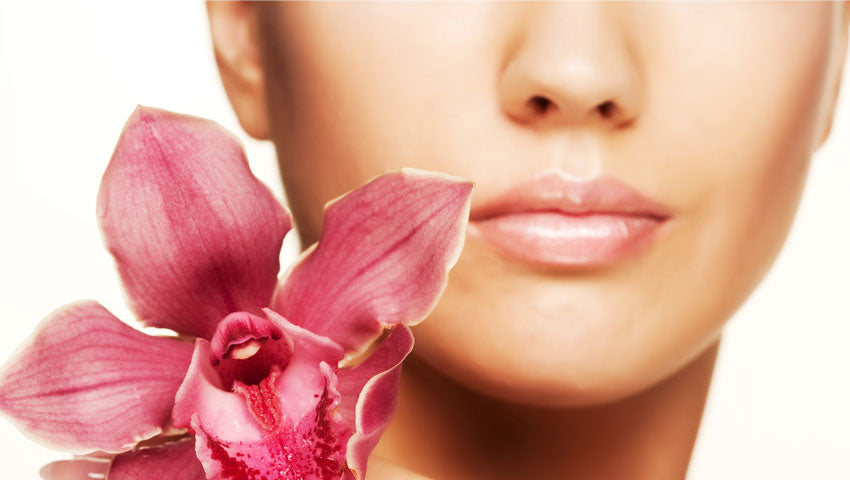 rostro y piel de una mujer con una flor de aroma